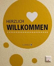 Ein Wandtattoo mit der Aufschrift Herzlich Willkommen.