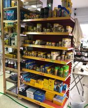 Im Aquariumraum stehen mehrere Regale mit Futter und Zubehör.