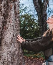 Webstudio Dresden Authentisches Outdoor Foto mit Frau an Baum, Fokus auf Naturverbundenheit und Achtsamkeit, inspirierender Moment.