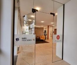Eingangstür  aus Glas im hellen Eingangsbereich.