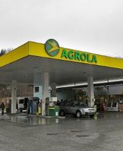 AGROLA Tankstelle in Thusis mit TopShop. Grosse Überdachung. Autos am Tanken. Regnerische Aufnahme. Grosser Vorplatz.