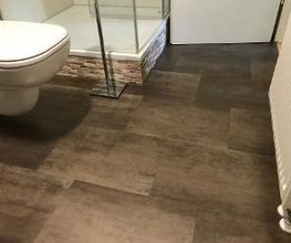 Vinylboden von Amtico in Metalloptik im Badezimmer verlegt. Statt einer Sockelleiste hat man sich hier für eine farblich passende dezente Silikonfuge entschieden.