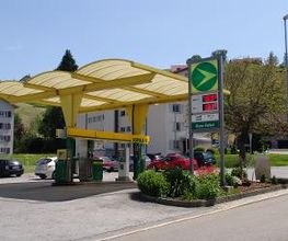 AGROLA Tankstelle in Heiden; Glasdach geschwungen über Tankstelle; im Vordergrund grosses Totem mit digitaler Preisanzeige