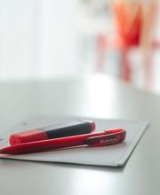 Auf einem weißen Tisch liegen ein Block und 2 Stifte.