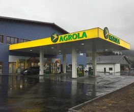 AGROLA Tankstelle in Zweisimmen, Bern, mit TopShop, regnerische Aufnahme, Vorplatz - nass, Tankstelle angeschlossen an blauem Gebäude