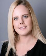 eine ca. 30 Jahre alte Frau mit blonden Haaren und einem schwarzen Oberteil