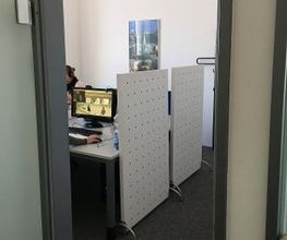 Seminarplätze mit Trennwand. An der Wand hängt ein Poster.