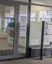 Außenansicht des Eingangsbereich. Glastür mit Blick ins Foyer. Briefkasten.