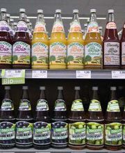 GETRÄNKE
Über 250 Quadratmeter erstreckt sich unser Getränkemarkt, den Sie unter dem Dach des EDEKA Henle finden. Hier erhalten Sie alkoholfreie Getränke wie verschiedene Sorten Wasser, fruchtige Säfte sowie süße Softdrinks. Doch auch Liebhaber regionaler und überregionaler Biere und insbesondere diejenigen, die sich gerne heimische oder internationale Weine schmecken lassen, kommen bei uns auf Ihre Kosten. Gerne weisen wir Sie auf unsere Weinexperten hin, die Ihnen zu jedem Gericht den passenden Tropfen empfehlen können. Sprechen Sie uns einfach an und wir helfen Ihnen, den perfekten Wein für Sie zu finden.