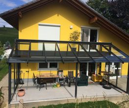 Terrassenüberdachung mit Dachüberstand und Balkongeländer aus Aluminium