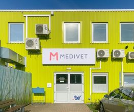 Grüne Pflanzen Kölle Fassade und weißer Medivet-Eingang