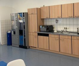 Helle, voll ausgestattete Teilnehmerküche mit Getränkeautomaten und Mikrowelle.