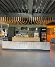 Küche im Eingangsbereich in unmittelbarer Nähe der großen Sitzgelegenheit, großer Tisch mit 12 Stühlen, Getränkeautomat, Gläser und Kaffeemaschine 