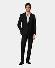 This black suit is cut to a tailored fit, offering a slim chest and waist for a fitted silhouette with padded shoulders. Paired with straight-leg trousers featuring a mid-rise and flat front.
