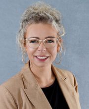 Frau mit Brille und beigem Blazer