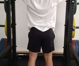 LIFE PERFORMANCE TRAINING | Personal Training Nürnberg - Rückansicht eines Athleten bei der Military Press mit der Langhantel, effektives Schultertraining für Haltung, Stabilität und Kraftaufbau.