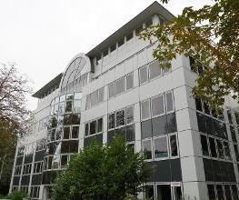 Gebäude mit vielen Fenstern und mehreren Bäumen.