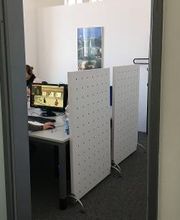 Seminarplätze mit Trennwand. An der Wand hängt ein Poster.