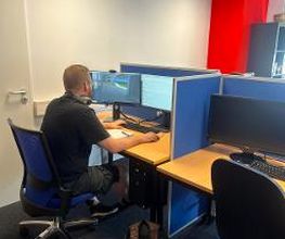 Ein Teilnehmer sitzt an seinem Arbeitsbereich und lernt.
