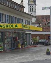 AGROLA Tankstelle in Alpnach Dorf; auf Aufnahme links in Gebäude; überdacht; im Hintergrund Kirchenturm