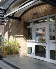 Außenansicht der Eingangstür. Glas mit weißer Umrandung und Überdachung.