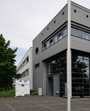 Außenansicht des Gebäudes. Graue Fassade mit Fenstern.