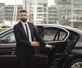 Chauffeur vor der Limousine in Münchens Innenstadt