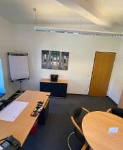 Tagesbüro mit Fenster und Besprechungstisch.