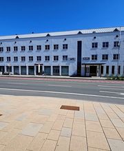 Ein weißes Bürogebäude an einer Straße.