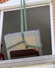 Der Nachtspeicherofen wird aus dem Fenster gezogen