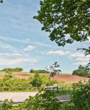 Ausblick vom FriedWald Sangerhausen auf den Parkplatz und angrenzende Felder.