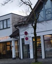 Vorderansicht des Bürogebäudes mit Ladenzeile im Erdgeschoss.