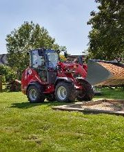 Weidemann Hoftrac 1390e mit Kabine und Leichtgutschaufel auf einem Spielplatz