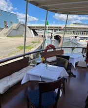 Gedeckte Tische im Außenbereich des Oberdecks mit Blick auf die Spree.