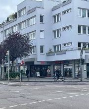 mehrstöckiges Bürogebäude, davor eine Straße.