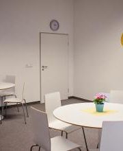 Pausenraum mit Tischen und Stühlen in weiß