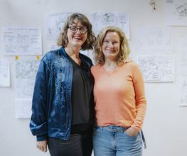 Abschlussmoment eines Workshops mit entstandenen Visualisierungen im Hintergrund bei Martina Grigoleit – Graphic Recording in Lübeck.