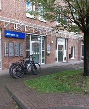 Außenansicht des Gebäudes. Eingangsbereich mit Beschilderung WBS TRAINING sowie anderer Unternehmen. Blaues Schild von der Allianz Versicherung an der Fassade. Es stehen Fahrräder vor dem Gebäude.