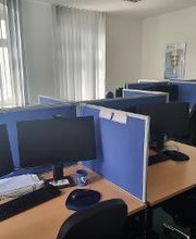 Mehrere Arbeitsplätze mit jeweils 2 Bildschirmen, einem Bürostuhl, Tastatur und Maus. 