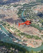A spectacular view from our FunFlights Helicopter-Tour over the Swiss Capital! The red helicopter flies above Bern’s historic old town, with the Federal Building, the Münster tower, and the turquoise River Aare clearly in sight. Exploring Bern from the