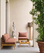 Outdoor entryway to Aelia Spa with terracotta planters, sculptural accents, and cushioned lounge chairs creating a tranquil Mediterranean-inspired atmosphere.