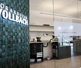 Blick in die Werkstatt, links ein beleuchtetes Vollbach Logo.