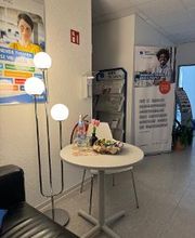 Aufenthaltssbereich mit kleinem runden Tisch und Couch mit Stehlampe