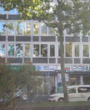 WBS TRAINING Gebäude hinter einem Baum an einer Straße