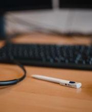 Nahaufnahme Tisch mit Tastatur, Maus, Headset und einem Stift.