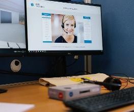 Arbeitsplatz mit zwei Bildschirmen, Tastatur und Kopfhörer