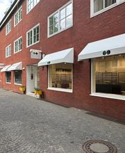Außenansicht von Newels Eyewear in Münster mit den großen Schaufenstern und dem Eingangsbereich des Brillengeschäfts. Das Fachgeschäft präsentiert Brillen, Sonnenbrillen und ausgewählte Designerfassungen in modernem Ambiente.