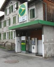 AGROLA Tankstelle in Grabs. Kleine Überdachung. Eine Tanksäule. Grosses AGROLA Logo auf Dach. Dahinter ein Wohhaus