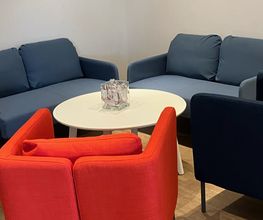 Aufenthaltsraum mit 2 gemütlichen blauen Sofas sowie einem roten Sessel.
