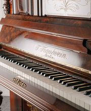 Ein antikes Klavier von F. Trautwein aus Berlin mit edler Holzverarbeitung und kunstvollem Design. Ein Beispiel traditioneller Klavierbaukunst aus Deutschland.